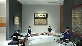 Гугак на фоне выставки корейской каллиграфии